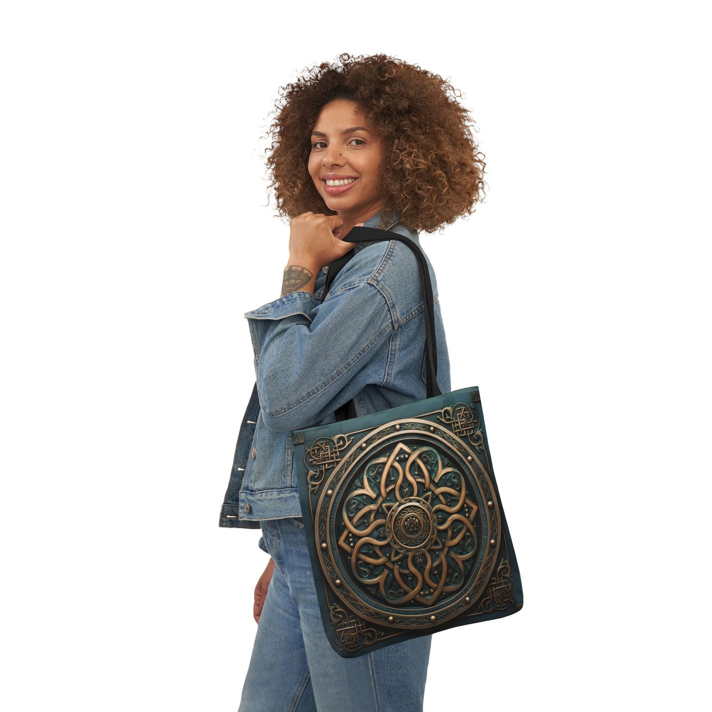 Woman wearing denim jacket carrying Celtic Shield Knot Turquoise and Bronze Tote Bag with intricate knot design