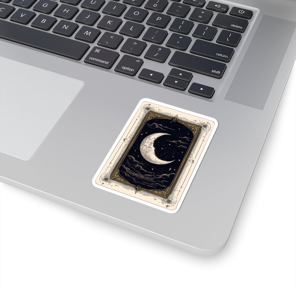 Laptop with a decorative sticker featuring a crescent moon design on the trackpad.