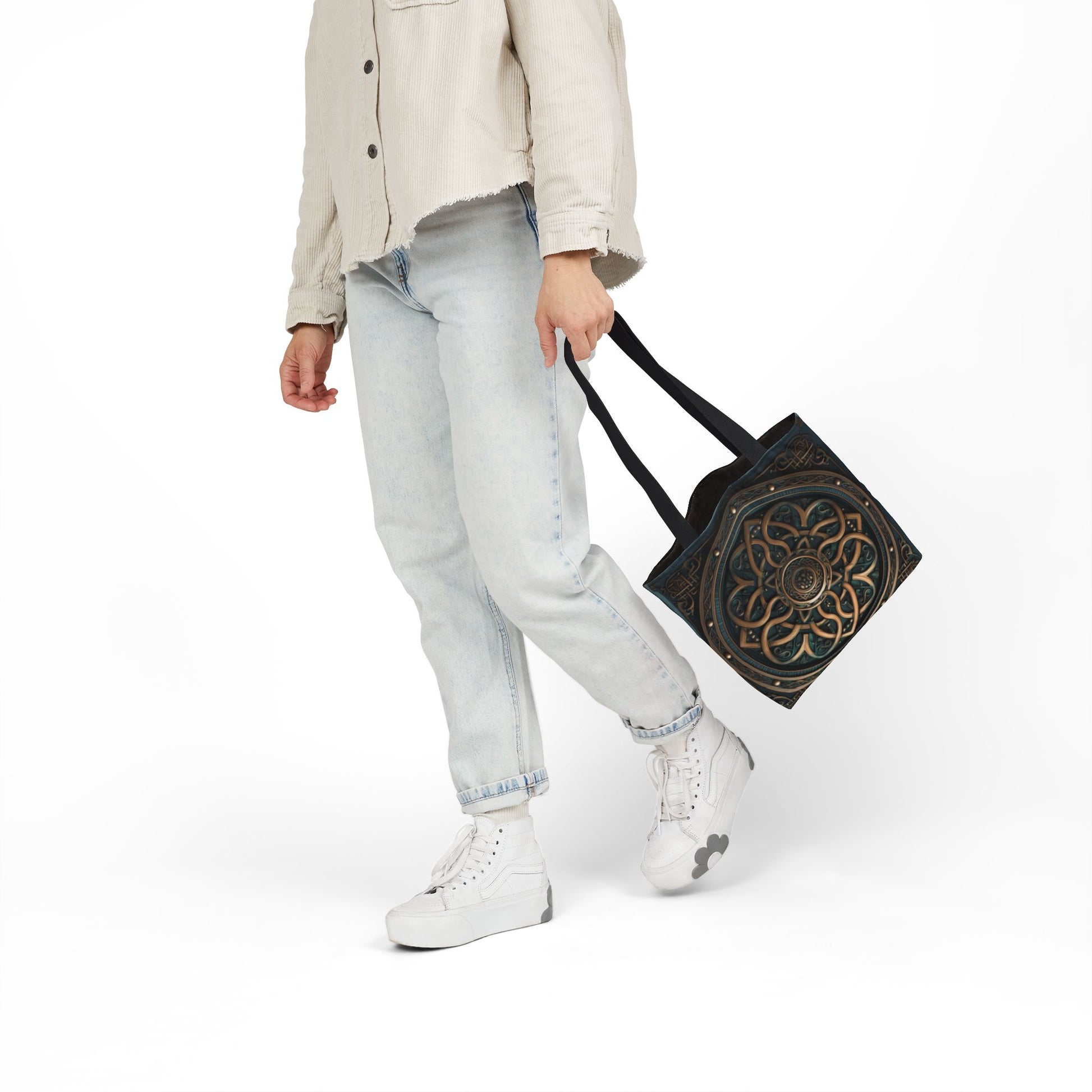 Person carrying Celtic Shield Knot Turquoise and Bronze Tote Bag with black handles and intricate design.